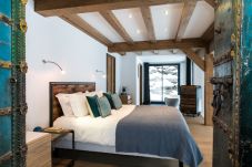 Chalet Belachat a une belle chambre principale avec coin salon et accès à la terrasse du jacuzzi 