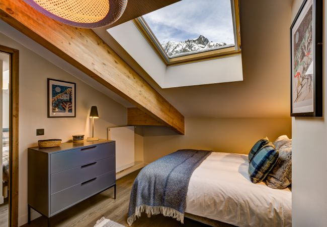 Chambre 2, lit sous la fenêtre Velux dans la pente du toit Dans Chambre 2 de White Pearl A36 le lit est sous la fenêtre Velux dans la pente du toit